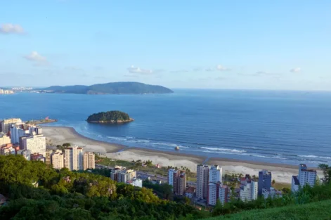 Vista aérea da cidade de Santos, localizada no litoral do estado de São Paulo, Brasil, com prédios e áreas verdes visíveis. A fotografia ilustra a questão do aquecimento dos oceanos que desafia as cidades costeiras.