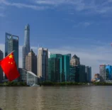 Vista dos arranha-céus de Xangai ao longo do rio Huangpu com a bandeira nacional da China