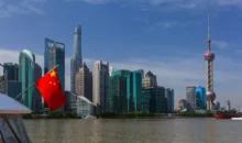 Vista dos arranha-céus de Xangai ao longo do rio Huangpu com a bandeira nacional da China