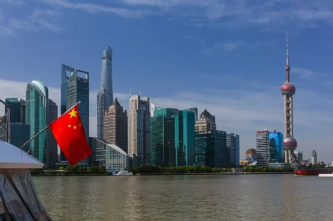 Vista dos arranha-céus de Xangai ao longo do rio Huangpu com a bandeira nacional da China