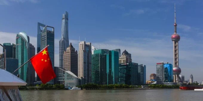 Vista dos arranha-céus de Xangai ao longo do rio Huangpu com a bandeira nacional da China