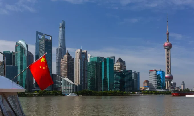 Vista dos arranha-céus de Xangai ao longo do rio Huangpu com a bandeira nacional da China