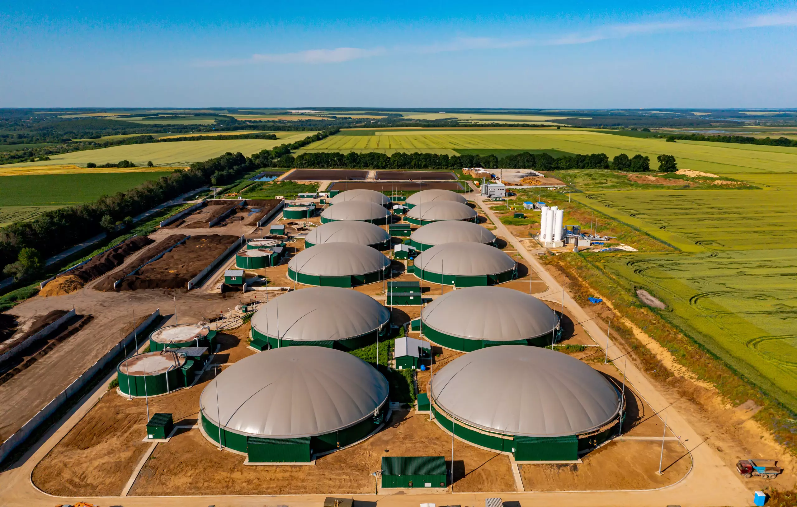 Instalações de biodigestores utilizados para transformar resíduos orgânicos em energia, demonstrando um sistema sustentável de resíduos que viram energia em uma área rural.