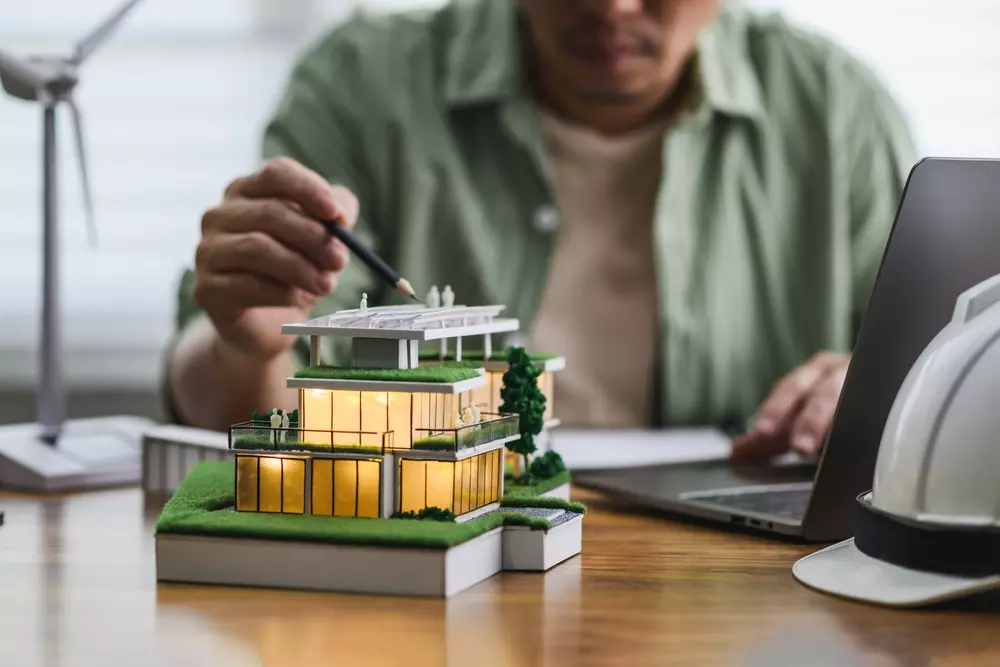 Engenheiro analisando modelo de edifício sustentável com foco nas soluções para combater o fenômeno das ilhas de calor, refletindo sobre o futuro do clima urbano.