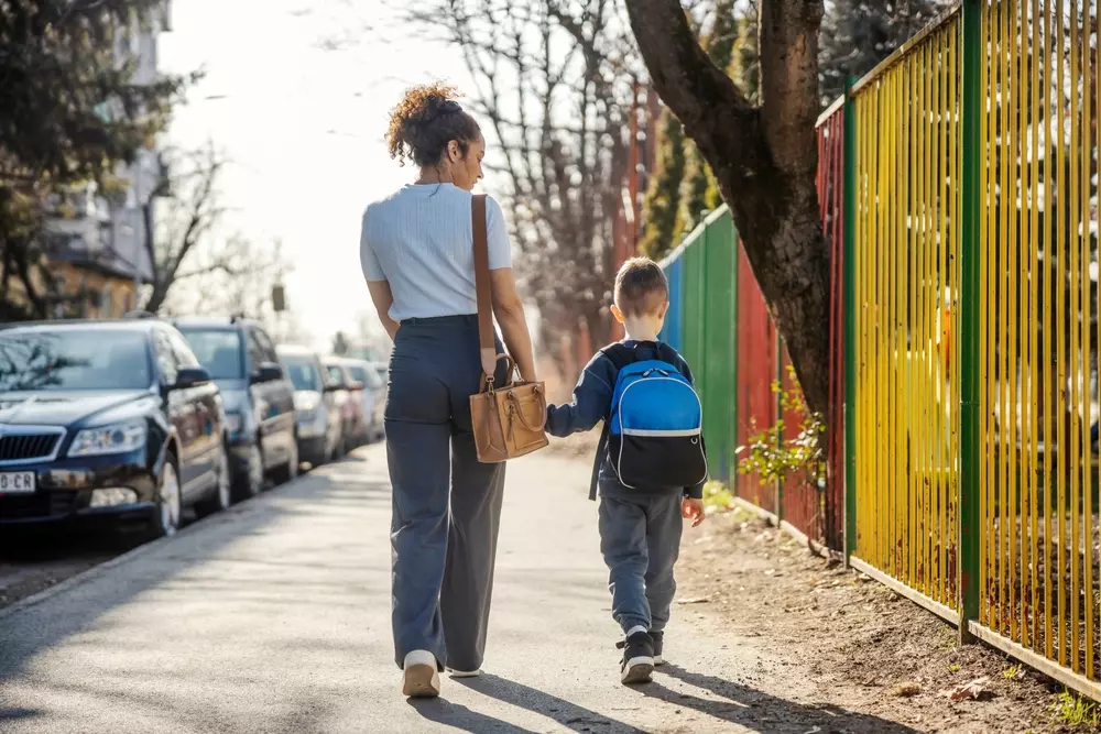 Perspectiva de uma mulher caminhando com uma criança na rua, destacando a importância da caminhabilidade para promover segurança e acessibilidade para todas as idades.