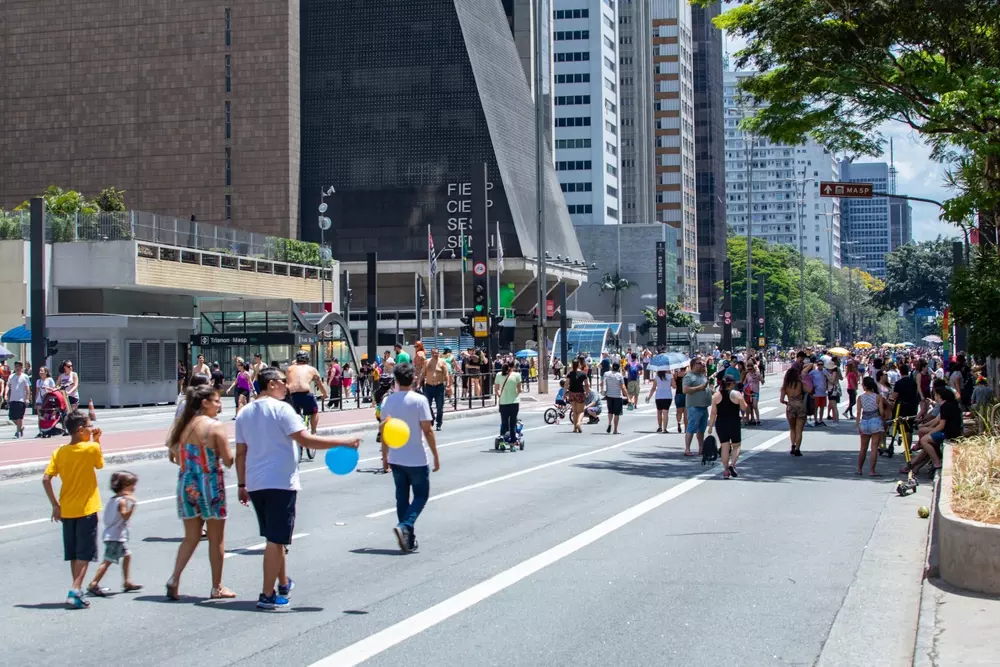 Rua no centro de São Paulo com muitas pessoas caminhando, pedalando e com acessibilidade, promovendo a caminhabilidade na cidade.