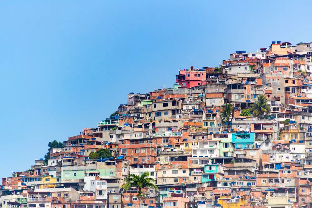 Uma comunidade do Rio de Janeiro simbolizando os desafios ambientais e a crise climática, com áreas densamente povoadas e construção improvisada.