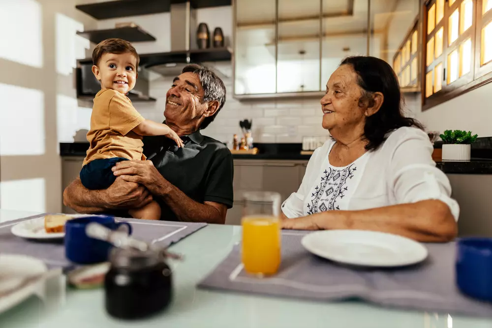 	
Família feliz em uma cozinha moderna, representando moradia digna e qualidade de vida para todas as idades.