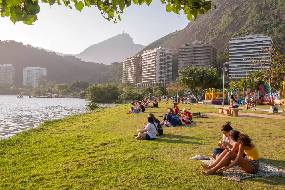 Pessoas relaxando e passando tempo ao ar livre em uma tarde ensolarada de domingo na Lagoa Rodrigo de Freitas, no Rio de Janeiro.