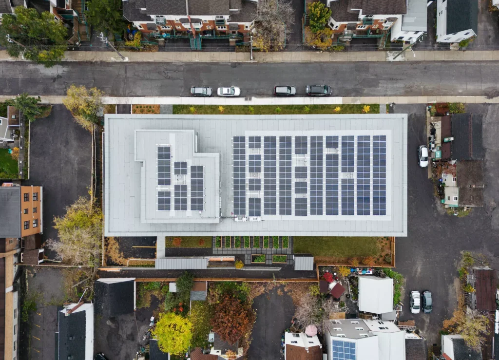 Projeto de habitação social na 159 Forward Avenue com painel solar, foco em casa passiva, energia sustentável e eficiência energética.