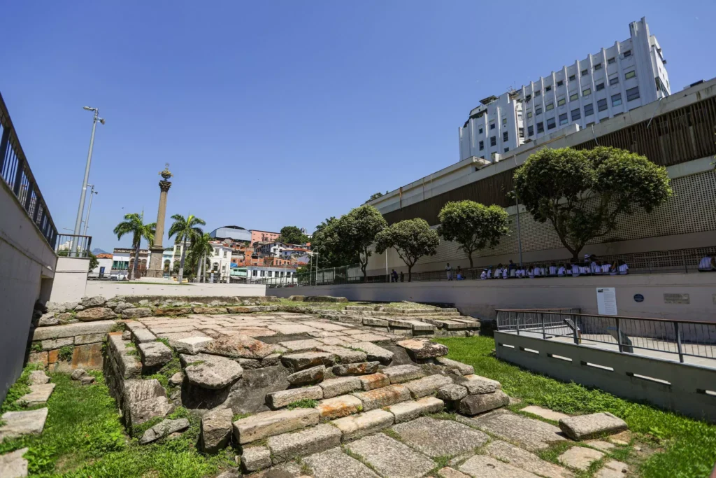 Vista da região do Cais do Valongo na Pequena África destacando a arquitetura afro-brasileira, com elementos históricos e modernos em uma área urbana com árvores e passarela, símbolo da cultura afro-brasileira.