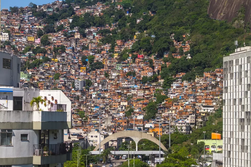 Vista da favela da Rocinha no Rio de Janeiro, destacando a arquitetura da quebrada com casas empilhadas na encosta, mostrando a diversidade urbana e a vida na periferia.
