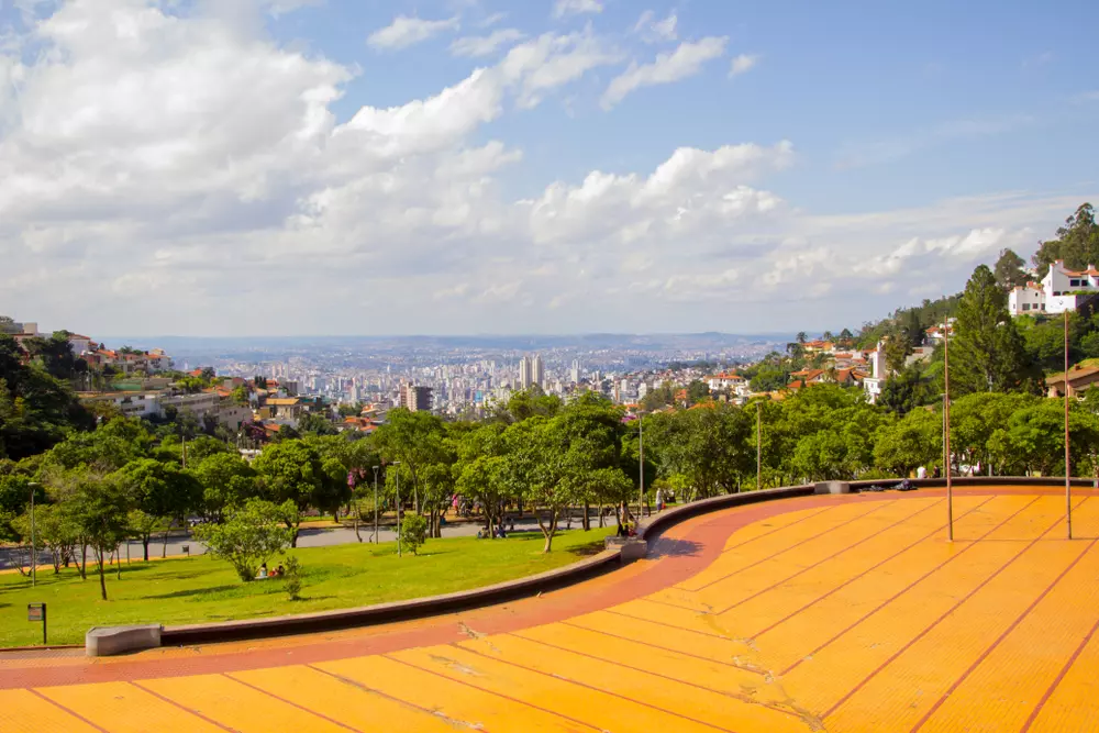 Praça Israel Pinheiro em Belo Horizonte celebrando a gentrificação verde com áreas verdes, árvores bem cuidadas e espaços públicos integrados à paisagem urbana.