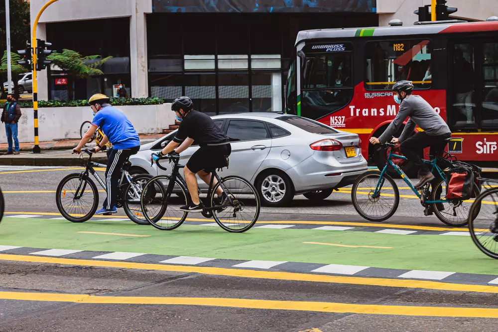 Rua aberta em Bogotá, na Colômbia. Ciclistas estão andando pela parte da ciclovia.