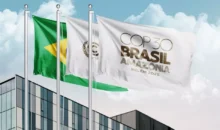 Bandeiras do Brasil e da COP Brasil Amazônia tremulam em frente a um prédio moderno durante o evento COP30 em Belém, onde foram estabelecidos os primeiros padrões globais para edificações sustentáveis e resilientes.