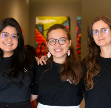 Equipe Raio que o Parta, formada por três jovens usando camisetas pretas e óculos. Gabrielle Arnour, Elisa Malcher e Elis Almeida