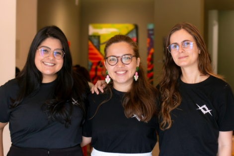 Equipe Raio que o Parta, formada por três jovens usando camisetas pretas e óculos. Gabrielle Arnour, Elisa Malcher e Elis Almeida