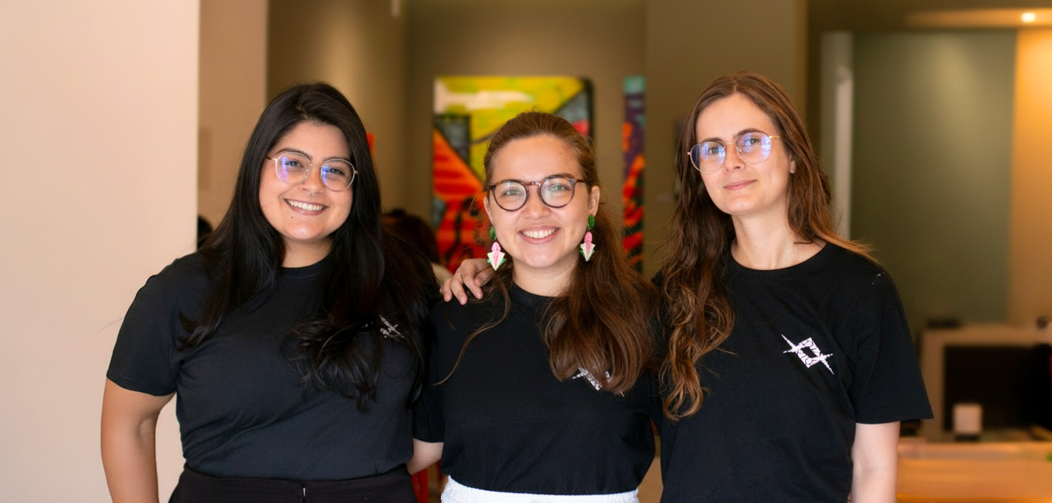 Equipe Raio que o Parta, formada por três jovens usando camisetas pretas e óculos. Gabrielle Arnour, Elisa Malcher e Elis Almeida