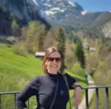 Pesquisadora Franciele Zanandrea fala entrevista sobre risco de deslizamentos. Na foto ela está em um ambiente com paisagem verde