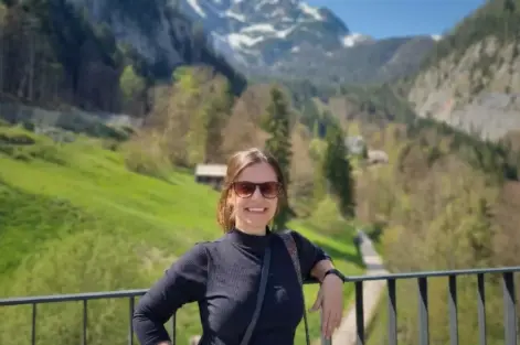 Pesquisadora Franciele Zanandrea fala entrevista sobre risco de deslizamentos. Na foto ela está em um ambiente com paisagem verde