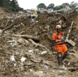 Deslizamento de terra na cidade de Petrópolis causado por risco de deslizamentos, com estruturas destruídas e equipes de resgate no local.