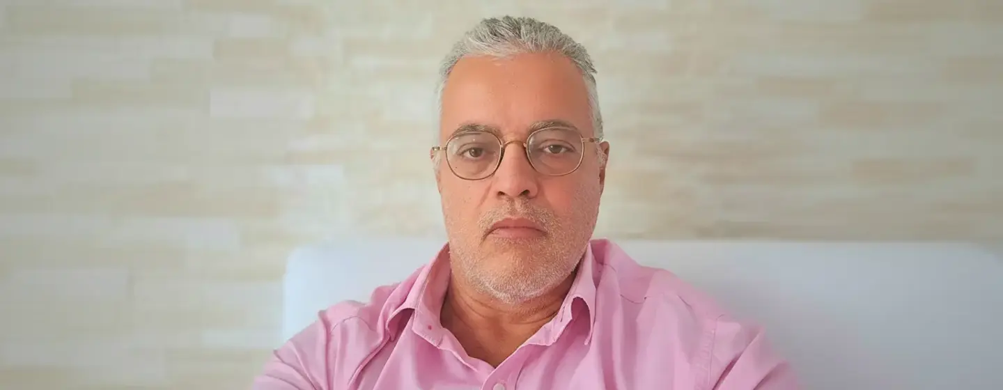 Ednildo Machado, biólogo formado pela Universidade do Estado do Rio de Janeiro (UERJ), posando em ambiente interno com parede de fundo neutra.