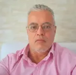 Ednildo Machado, biólogo formado pela Universidade do Estado do Rio de Janeiro (UERJ), posando em ambiente interno com parede de fundo neutra.