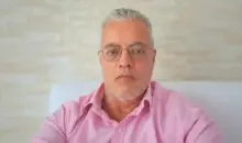 Ednildo Machado, biólogo formado pela Universidade do Estado do Rio de Janeiro (UERJ), posando em ambiente interno com parede de fundo neutra.