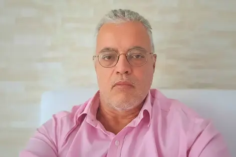 Ednildo Machado, biólogo formado pela Universidade do Estado do Rio de Janeiro (UERJ), posando em ambiente interno com parede de fundo neutra.