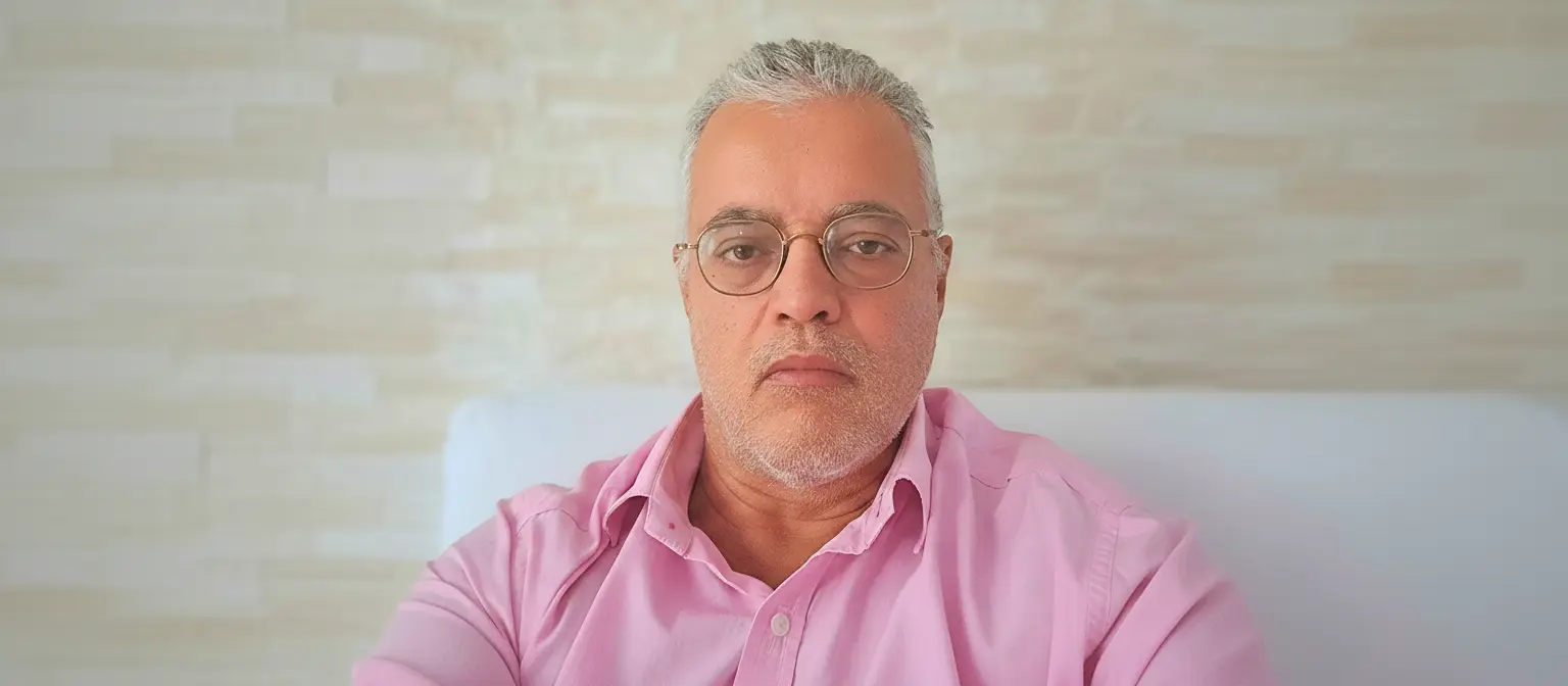 Ednildo Machado, biólogo formado pela Universidade do Estado do Rio de Janeiro (UERJ), posando em ambiente interno com parede de fundo neutra.