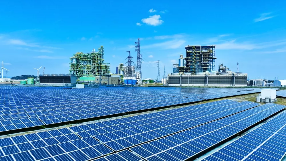 Uma usina de biomassa moderna com painéis solares em primeiro plano, destacando a geração de energia limpa e sustentável.