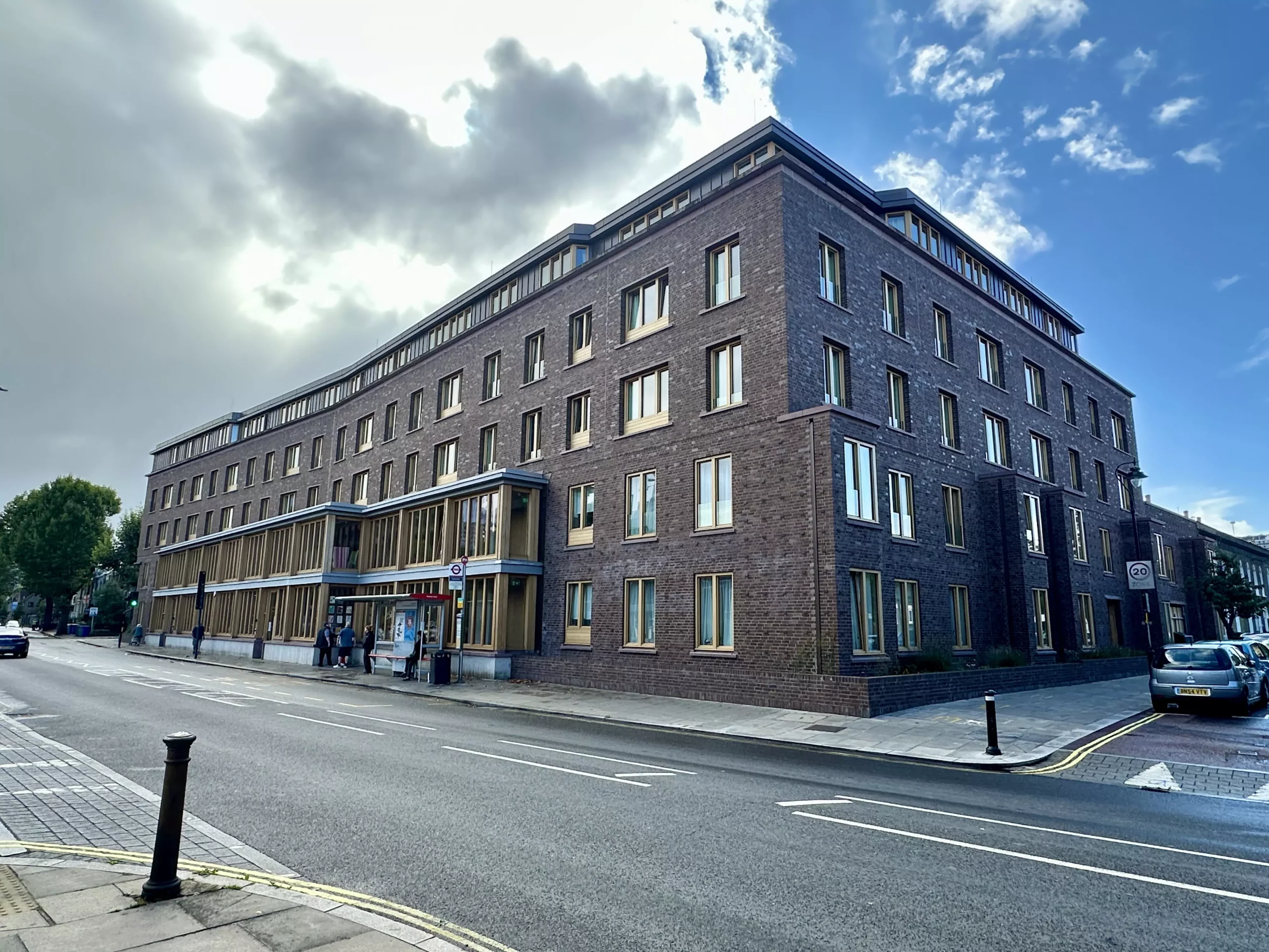 Arquitetura moderna no Appleby Blue em Londres, destacando o design que evita afastar a velhice do centro da cidade, com fachada de tijolos escuros e janelas amplas.