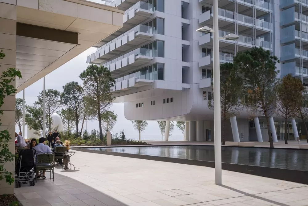 Pessoas em um café no novo bairro Mareterra construído no mar. 