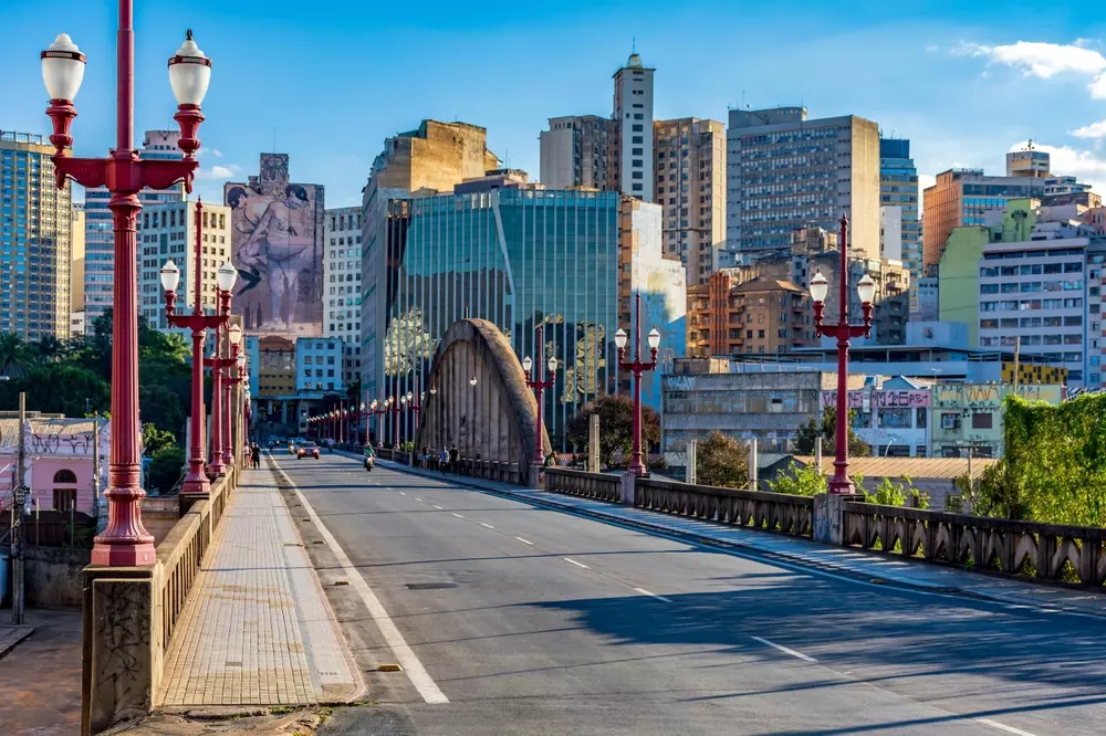 Edifícios e grafites no centro da cidade de Belo Horizonte e no viaduto de Santa Tereza com postes de luz coloridos
