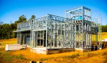 Estrutura de Steel Frame para construção a seco de uma casa moderna em andamento, com estrutura metálica visível, em terreno ao ar livre.