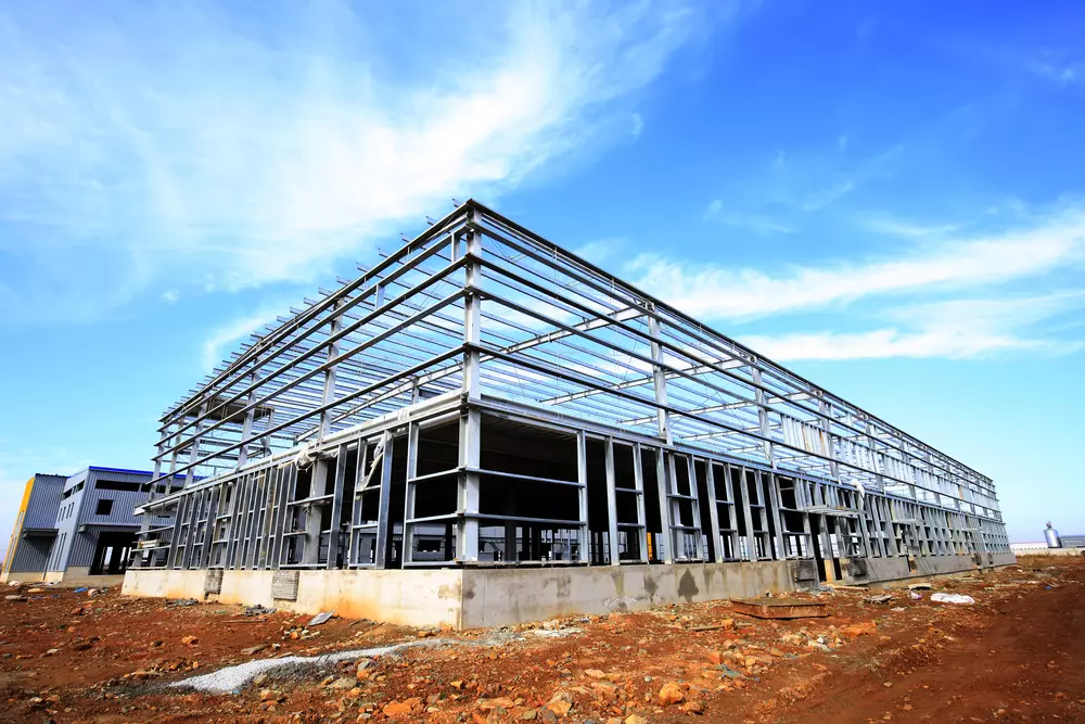 Construção de edifício com estrutura de steel frame em andamento, destacando a estrutura metálica e o uso de aço na construção civil moderna.