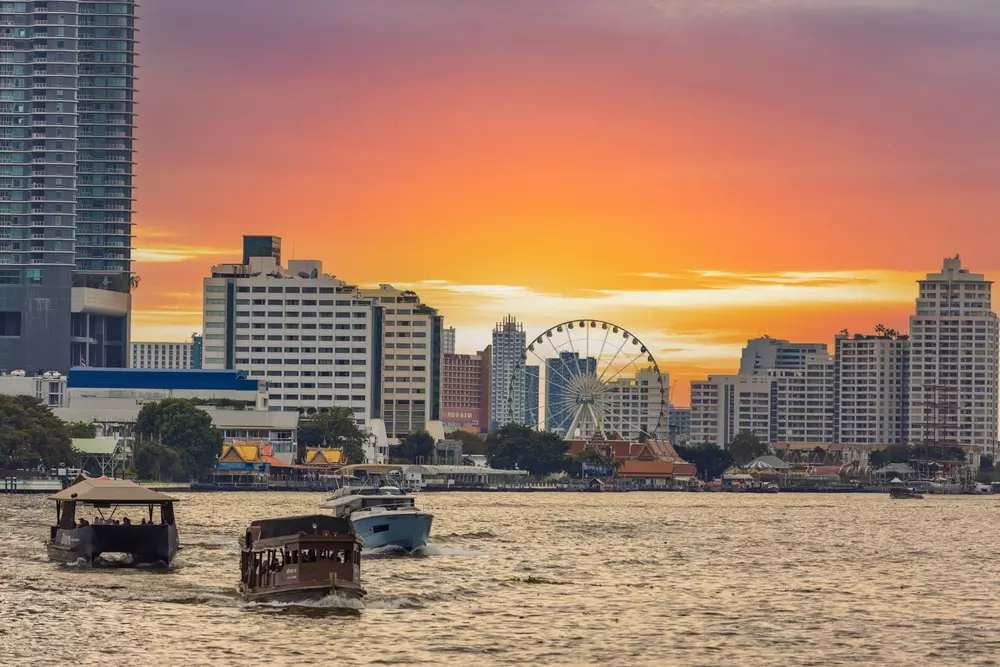 Roda-gigante Asiatique Sky do rio Chao Phraya contra o céu laranja do pôr do sol em Bangkok, Tailândia